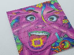 Colorful LSD blotter paper with unique vibrant patterns on dark reflective surface - 200µg premium quality tabs available in UK and Europe